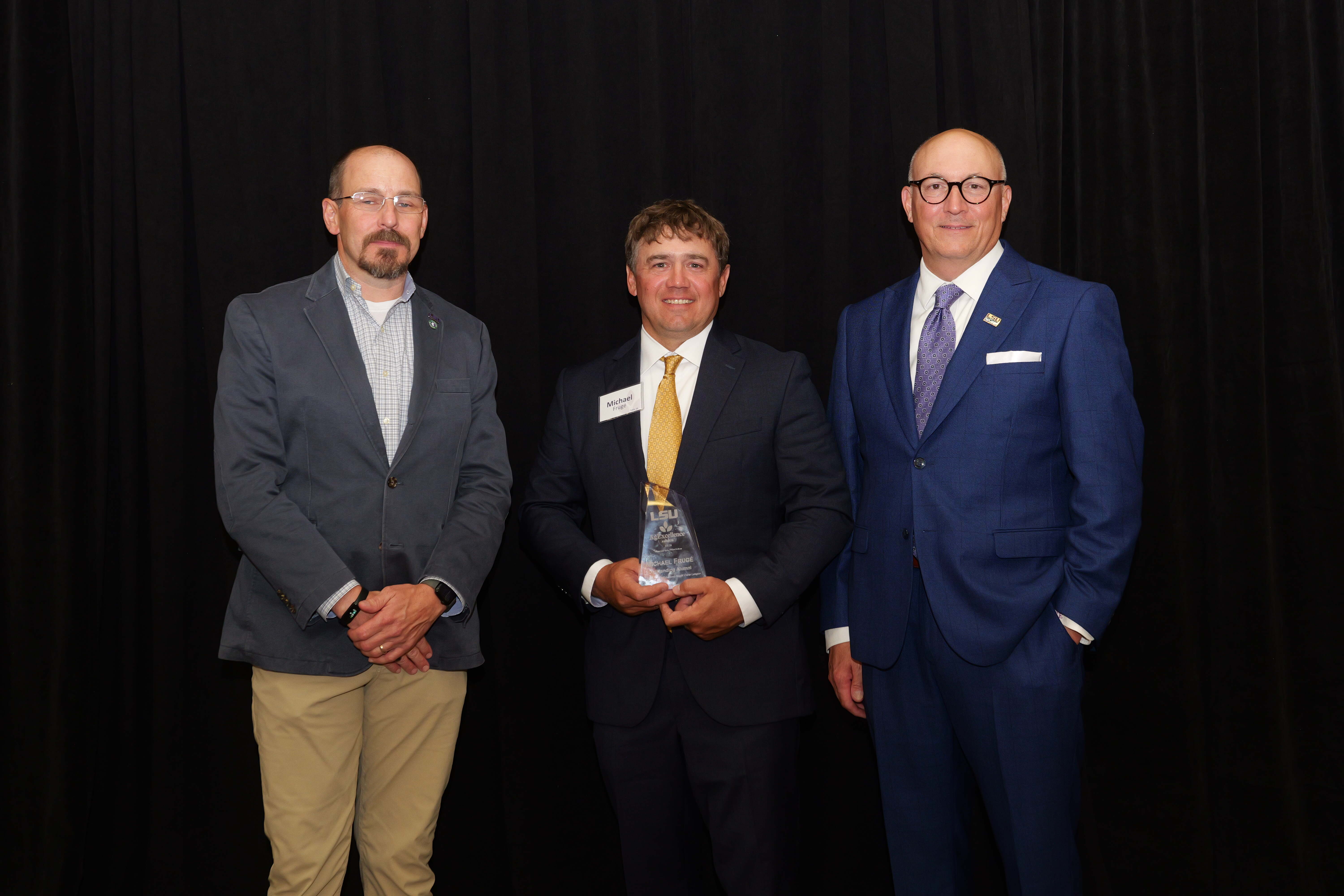 Michael Fruge recieving an alumni award from Matt Lee