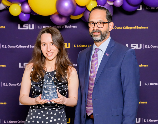 Stephanie Walton holds her award next to former LSU Ourso dean Jared Llorens