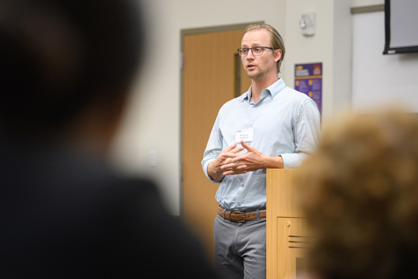 Roy Heidelberg lectures at podium. 