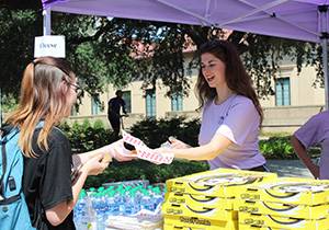 People Academic Kick-Off Table giving Water and King Cake