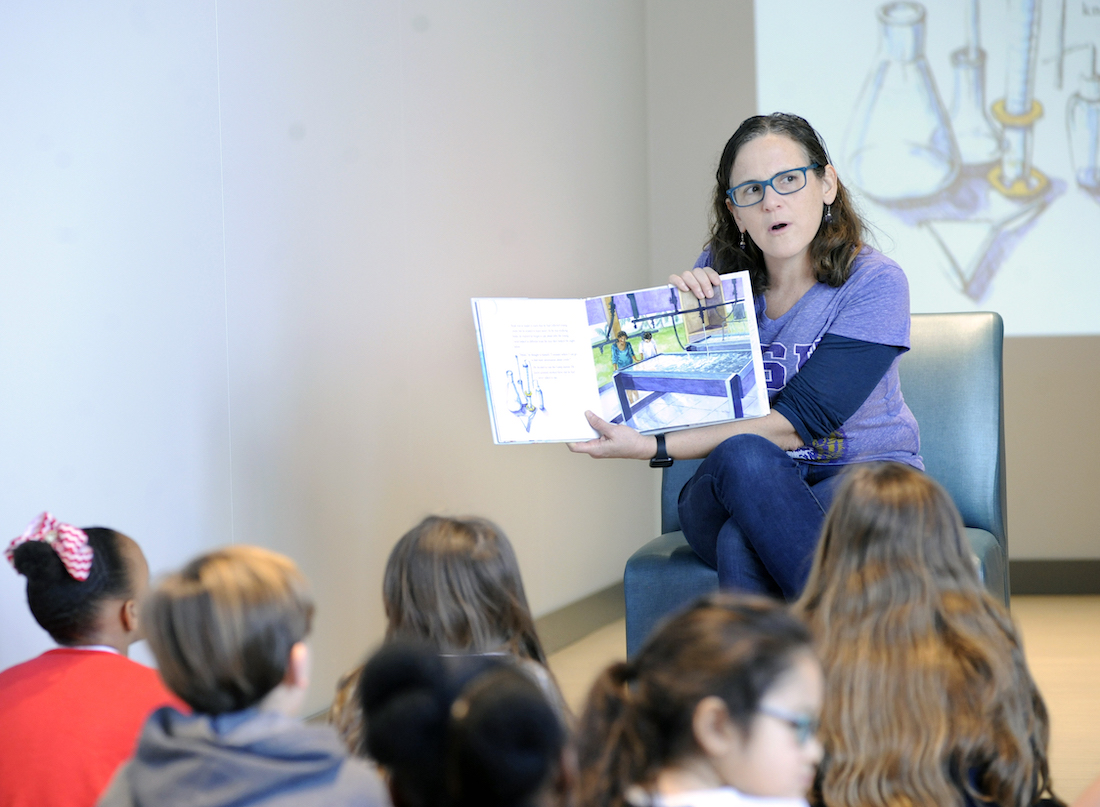 Dr. Morgan Kelly reads a book to a group of kids for LSU Science STEM Story Time.