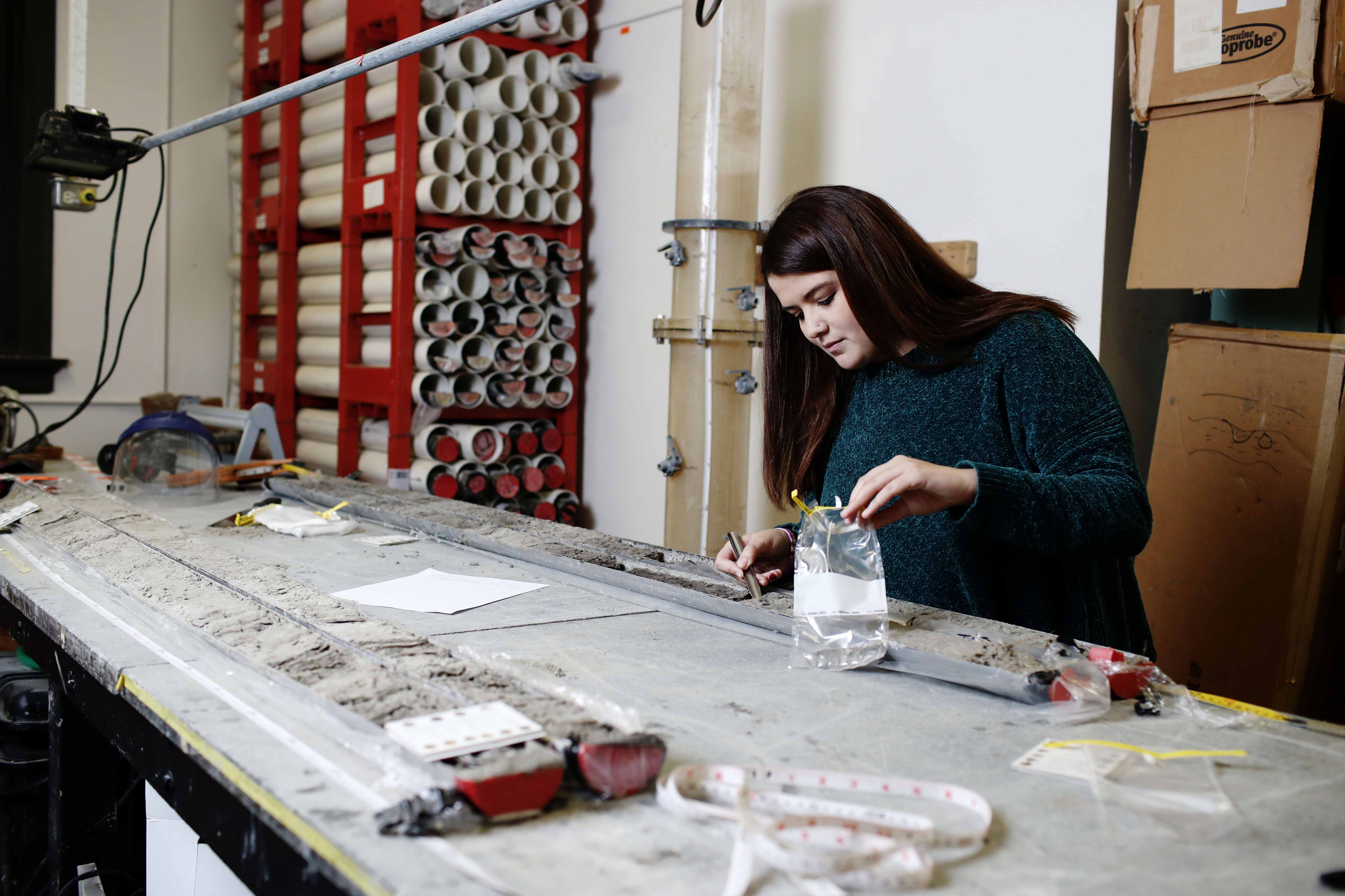 Student examines a sediment core sample.